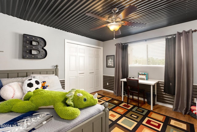 bedroom featuring ceiling fan, a closet, and hardwood / wood-style flooring