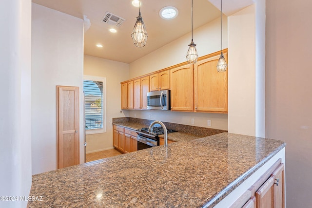 kitchen with pendant lighting, light brown cabinets, light tile patterned floors, and appliances with stainless steel finishes