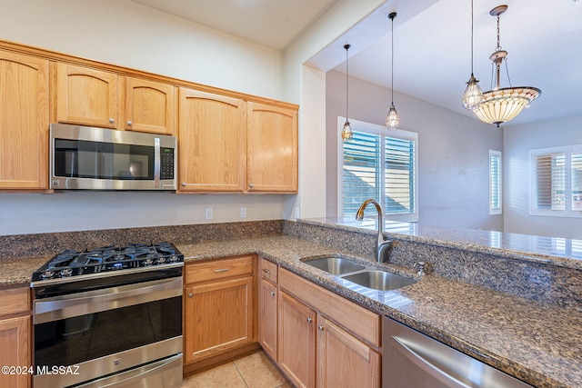 kitchen featuring light brown cabinetry, stainless steel appliances, sink, light tile patterned floors, and decorative light fixtures