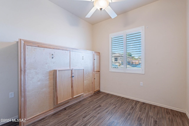 unfurnished bedroom with ceiling fan and dark wood-type flooring