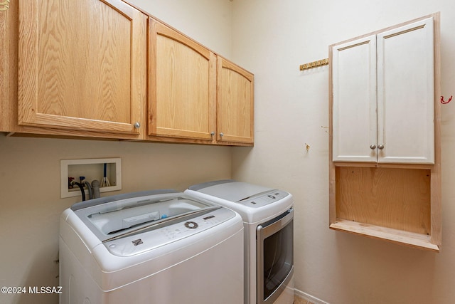 washroom with cabinets and washing machine and dryer