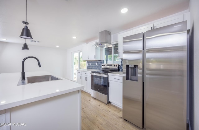 kitchen with decorative light fixtures, stainless steel appliances, white cabinetry, and sink