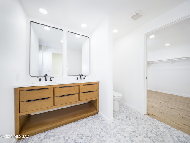 bathroom featuring wood-type flooring, vanity, and toilet