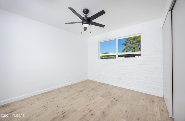 empty room with ceiling fan and light hardwood / wood-style flooring