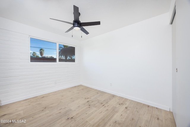 empty room with ceiling fan and light hardwood / wood-style flooring