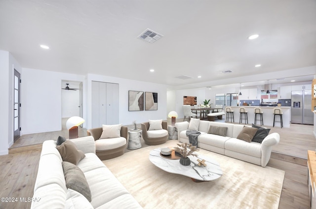 living room with ceiling fan and light wood-type flooring