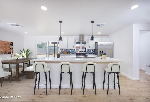 kitchen featuring stainless steel fridge with ice dispenser, ventilation hood, decorative light fixtures, white cabinets, and light wood-type flooring