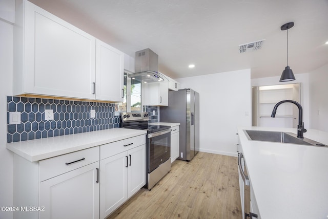 kitchen featuring island exhaust hood, stainless steel appliances, sink, light hardwood / wood-style flooring, and hanging light fixtures