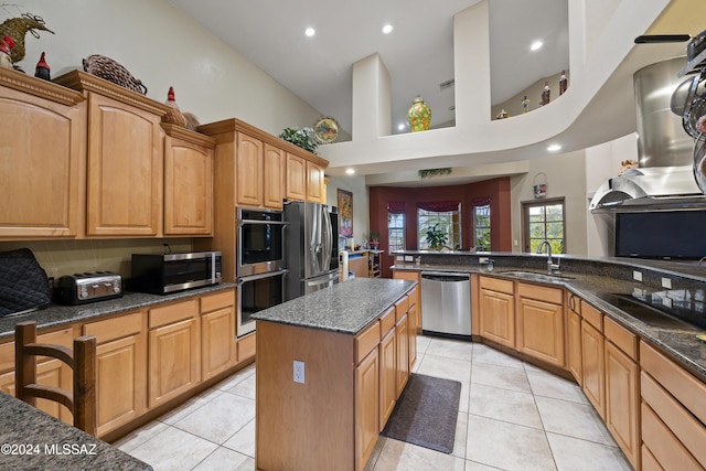 kitchen featuring a high ceiling, sink, a kitchen island, appliances with stainless steel finishes, and light tile patterned flooring