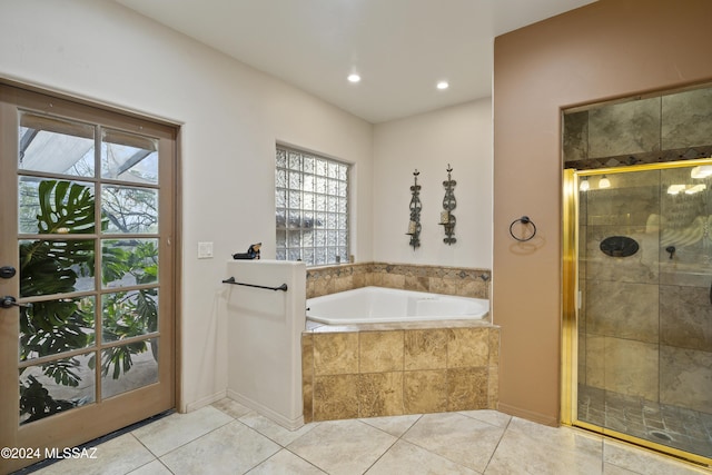 bathroom with tile patterned flooring, separate shower and tub, and a wealth of natural light