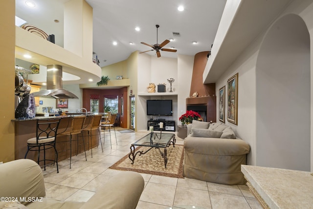 tiled living room featuring ceiling fan and high vaulted ceiling