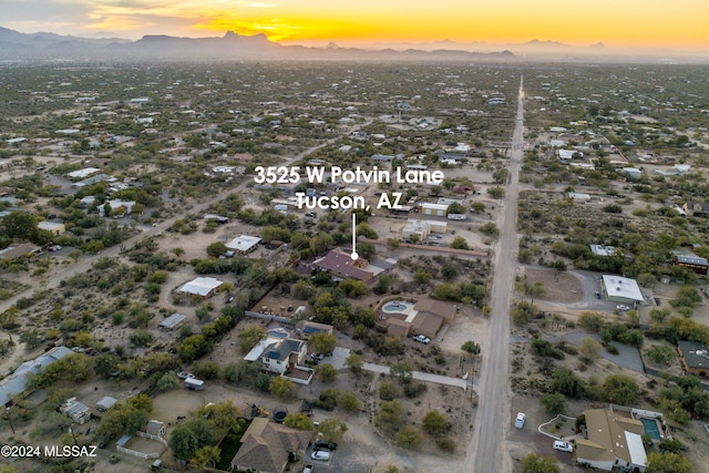 aerial view at dusk featuring a mountain view