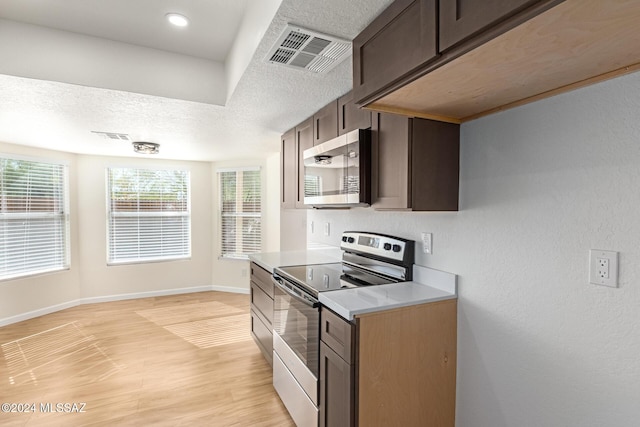 kitchen with dark brown cabinetry, stainless steel appliances, a textured ceiling, and light wood-type flooring