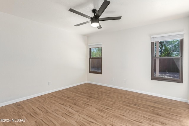 spare room with ceiling fan and light wood-type flooring