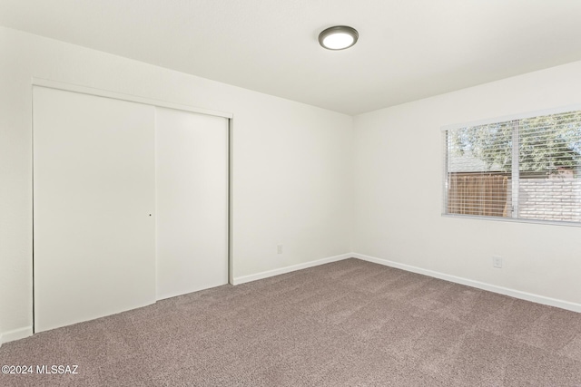 unfurnished bedroom featuring carpet and a closet