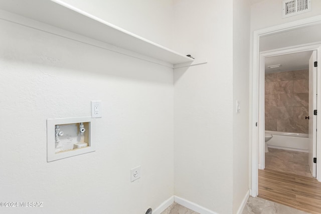 washroom featuring electric dryer hookup, hookup for a washing machine, and light wood-type flooring