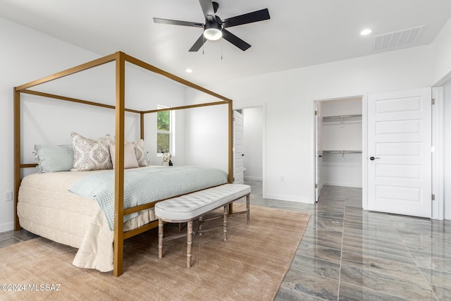 bedroom with a closet, ceiling fan, ensuite bathroom, and a spacious closet