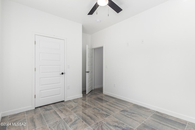 unfurnished bedroom with ceiling fan and a closet