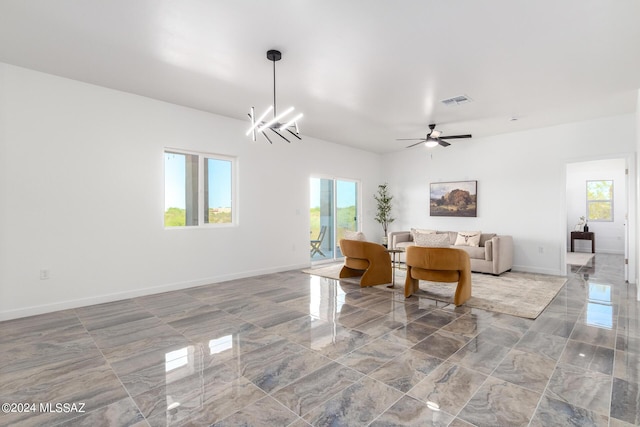 living room with ceiling fan with notable chandelier