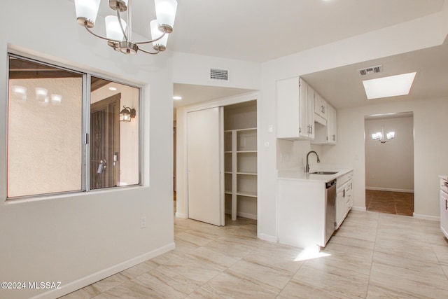 kitchen with a skylight, dishwasher, sink, a notable chandelier, and white cabinets