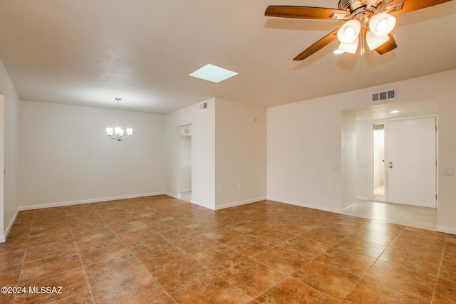 tiled spare room with ceiling fan with notable chandelier