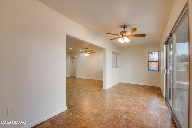 tiled empty room featuring ceiling fan