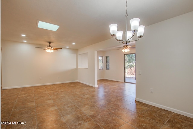 tiled spare room featuring ceiling fan with notable chandelier