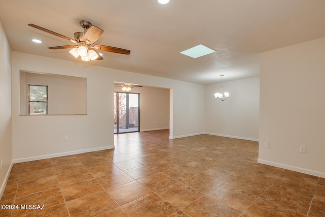 tiled spare room with ceiling fan with notable chandelier