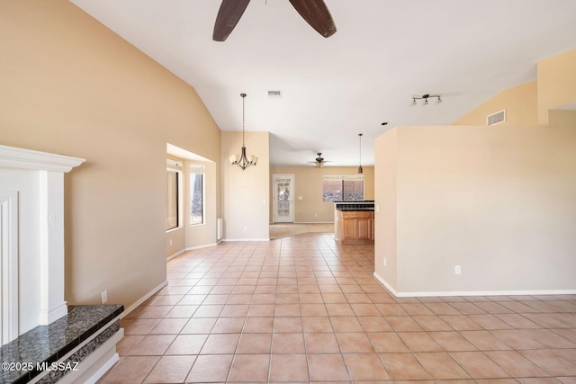 unfurnished living room featuring lofted ceiling, light tile patterned floors, rail lighting, and ceiling fan with notable chandelier