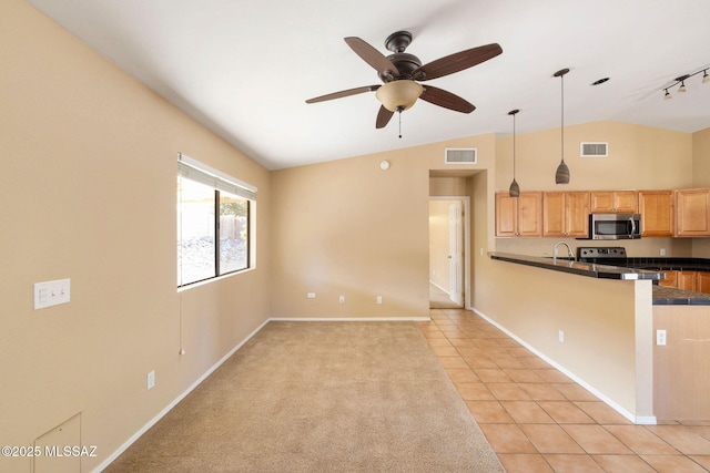 kitchen featuring lofted ceiling, light brown cabinets, hanging light fixtures, light tile patterned flooring, and ceiling fan