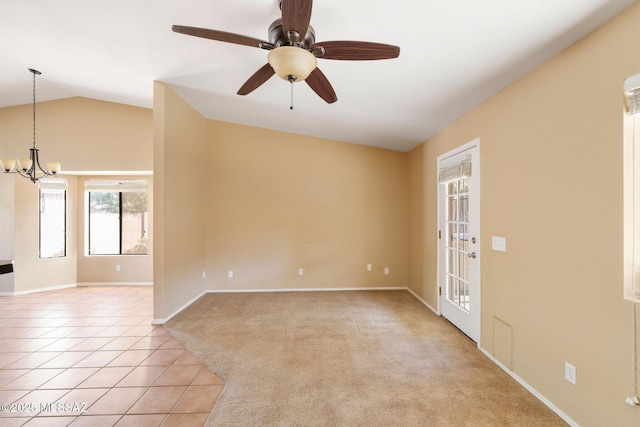 unfurnished room with ceiling fan with notable chandelier, light tile patterned floors, and vaulted ceiling