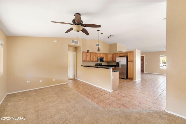 kitchen with light tile patterned floors, kitchen peninsula, ceiling fan, appliances with stainless steel finishes, and decorative light fixtures