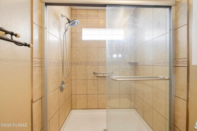 bathroom featuring a shower with door