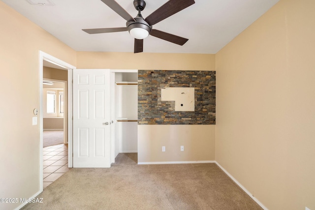 unfurnished bedroom with ceiling fan, light colored carpet, and a closet