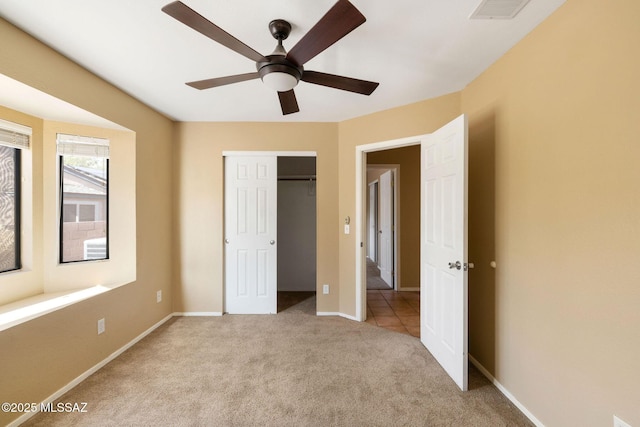 unfurnished bedroom with ceiling fan, light colored carpet, and a closet