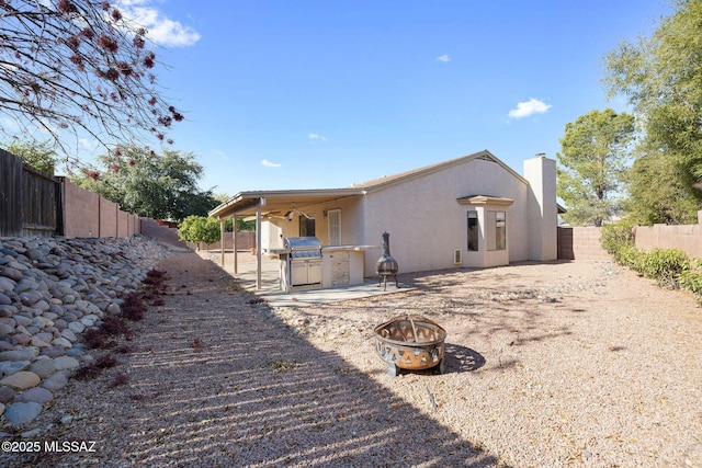 rear view of property featuring a fire pit