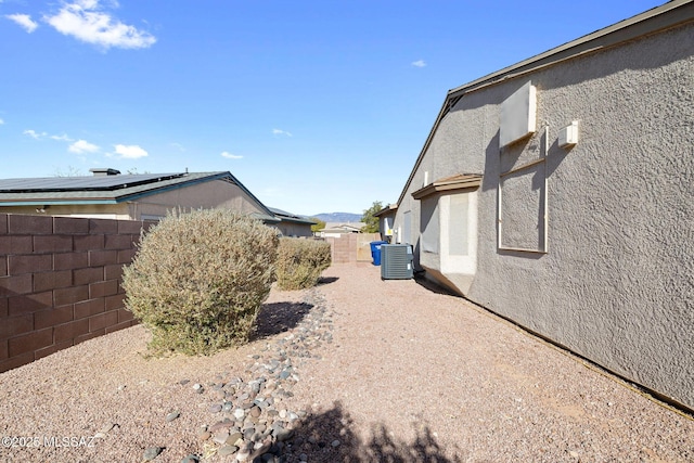 view of home's exterior featuring solar panels and central air condition unit