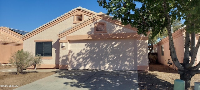 view of front of house with a garage, concrete driveway, a tiled roof, fence, and stucco siding