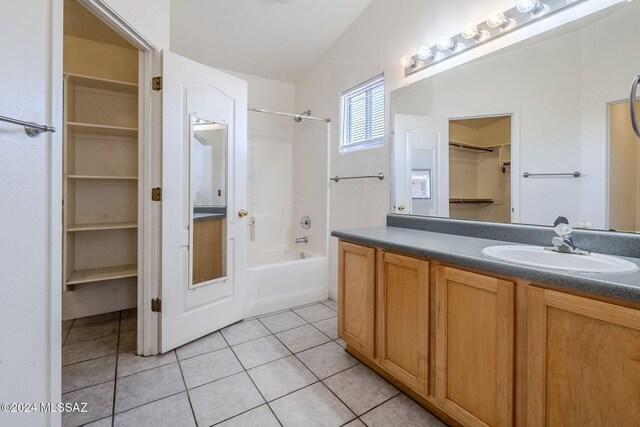 bathroom featuring tile patterned flooring, vanity,  shower combination, and vaulted ceiling