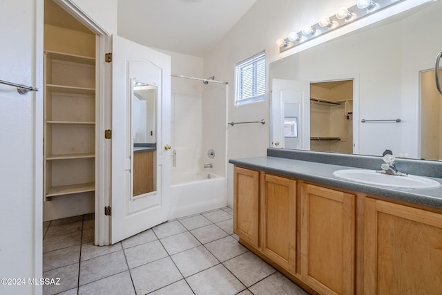 full bathroom with tile patterned flooring, bathtub / shower combination, a walk in closet, and vanity