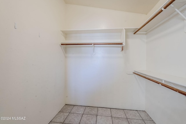 walk in closet with light tile patterned floors