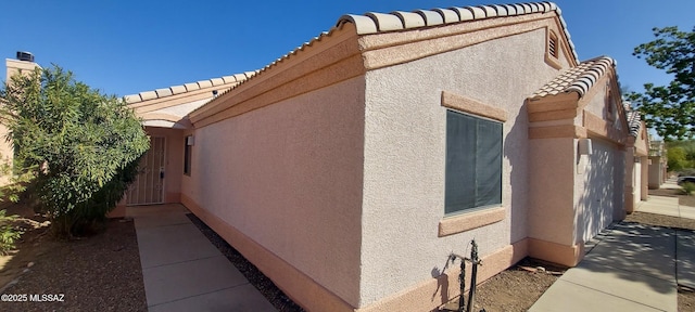 view of property exterior featuring a tiled roof and stucco siding