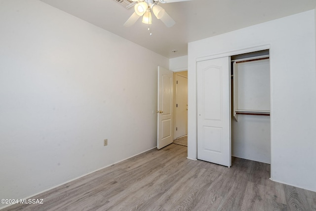 unfurnished bedroom featuring a closet, light hardwood / wood-style flooring, and ceiling fan