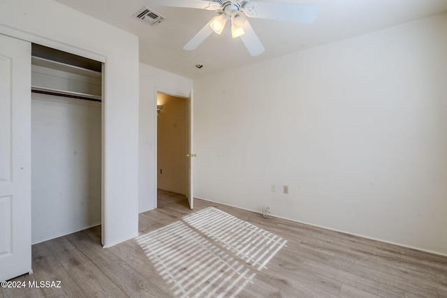 unfurnished bedroom featuring light wood-style flooring, visible vents, ceiling fan, and a closet