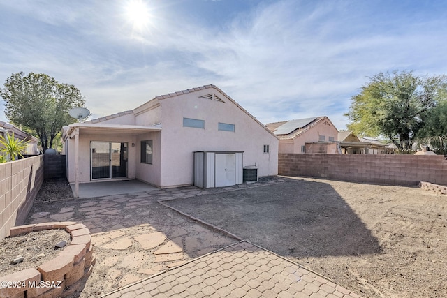 back of property with a patio area, a fenced backyard, central AC unit, and stucco siding