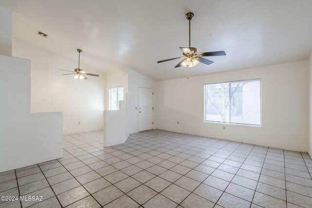 tiled spare room with ceiling fan, plenty of natural light, and vaulted ceiling