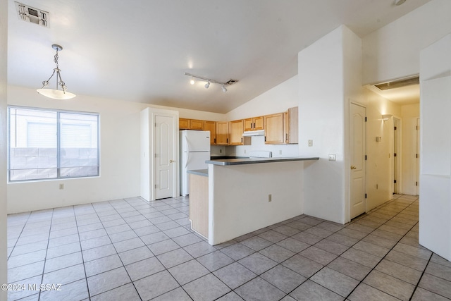 kitchen featuring lofted ceiling, white refrigerator, hanging light fixtures, light tile patterned flooring, and kitchen peninsula