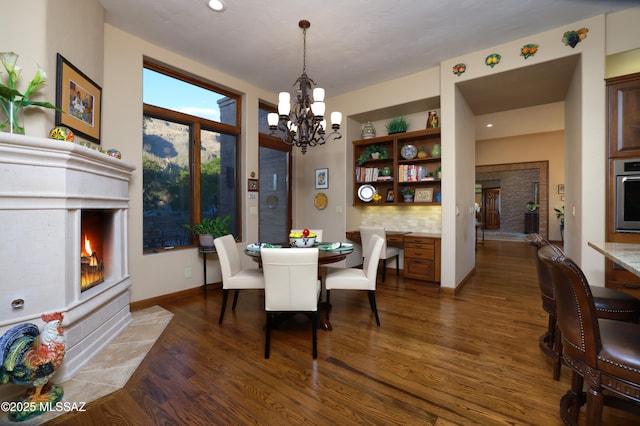 dining area with a notable chandelier and dark hardwood / wood-style flooring