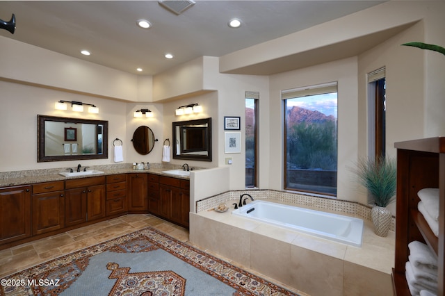 bathroom with tiled bath and vanity