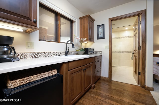 kitchen featuring sink, dark hardwood / wood-style flooring, and tasteful backsplash